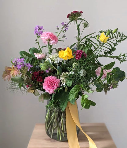 vase of British spring flowers in pink purple and yellow